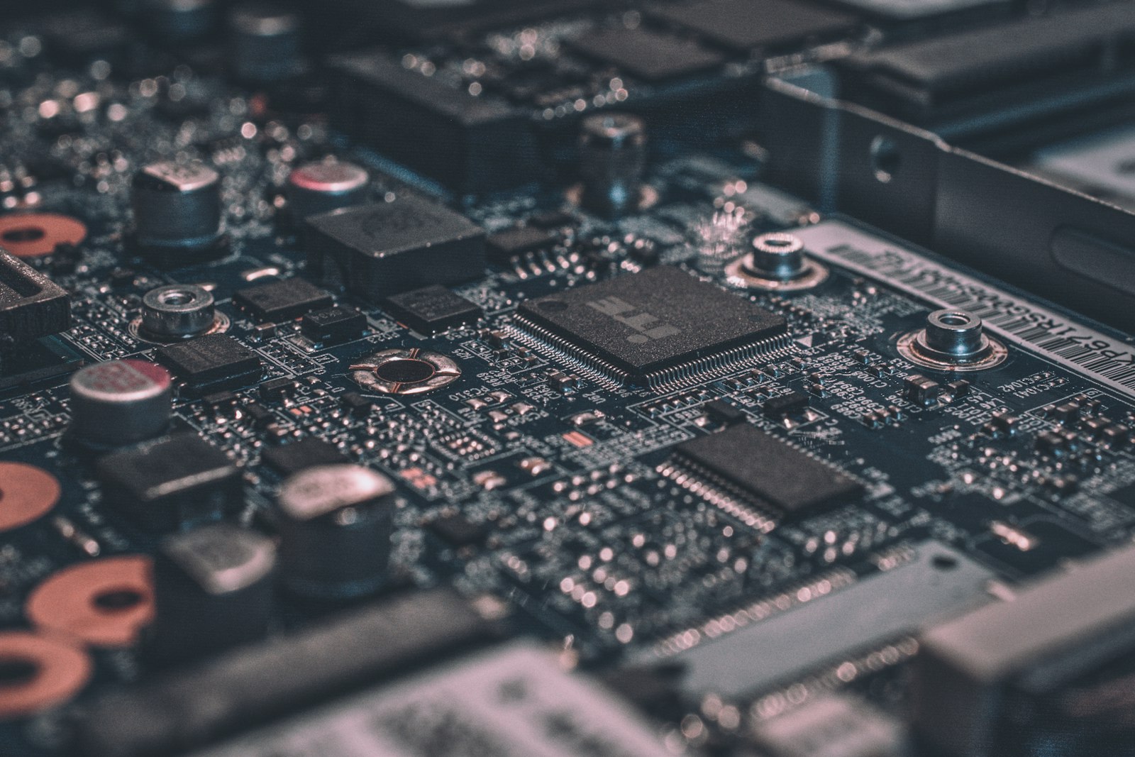 Close-up of a dark printed circuit board with integrated circuits and surface-mount components